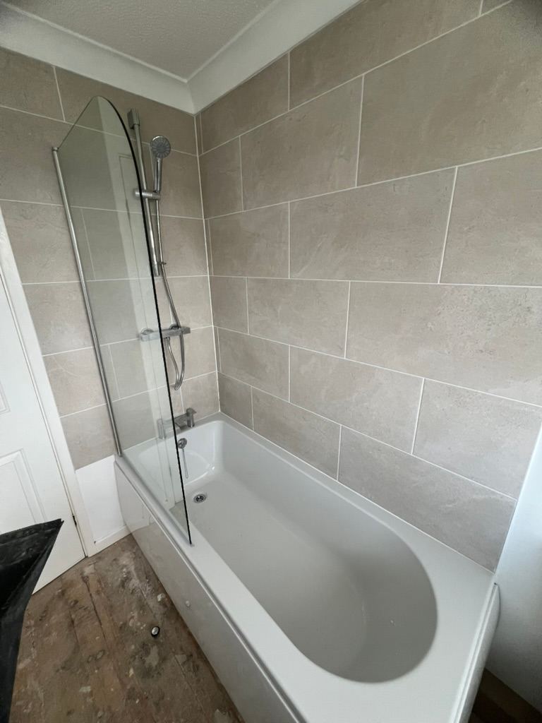 Newly fitted bath with a shower screen and full height tiling