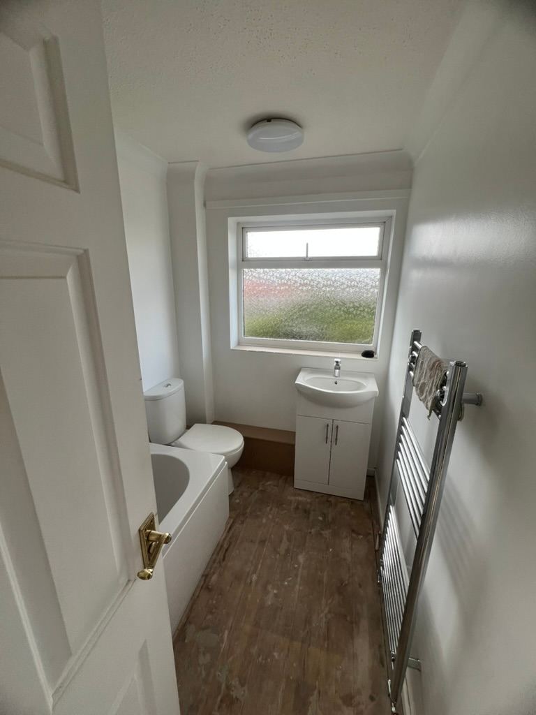 Finished bathroom with a vanity unit and heated towel rail