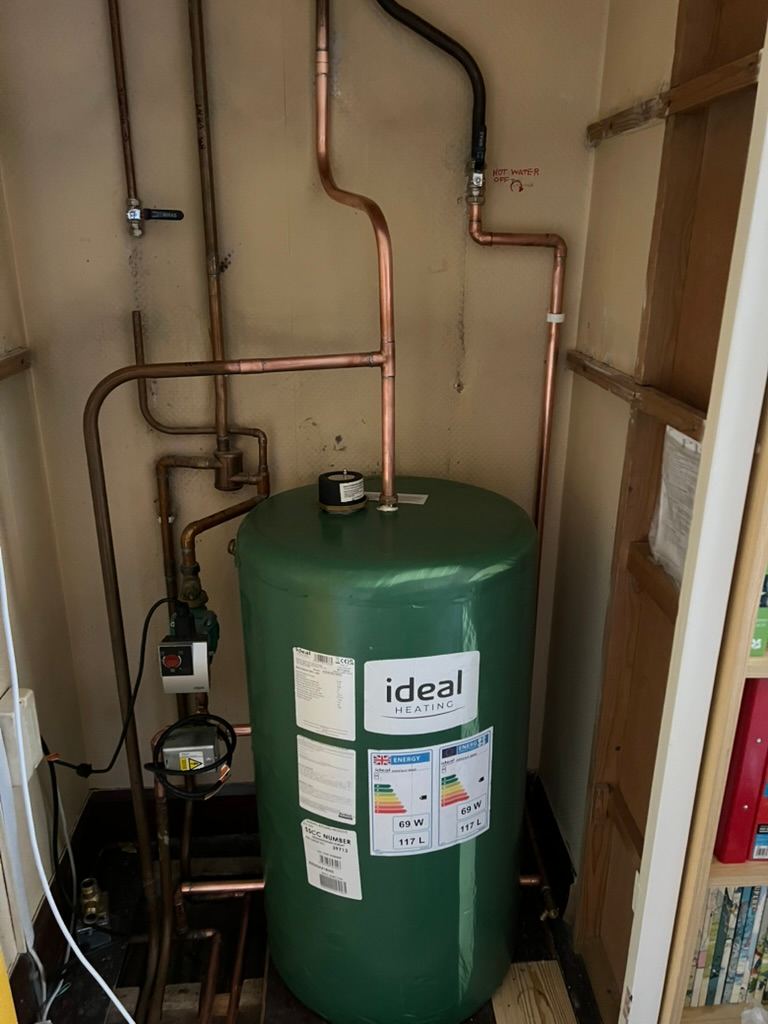 New hot water cylinder and pipework in an airing cupboard
