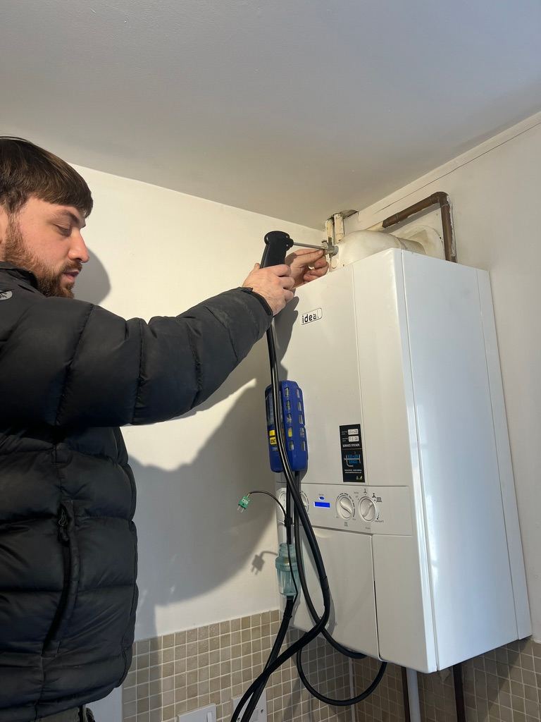 Testing a boiler with a flue gas analyser during a safety check