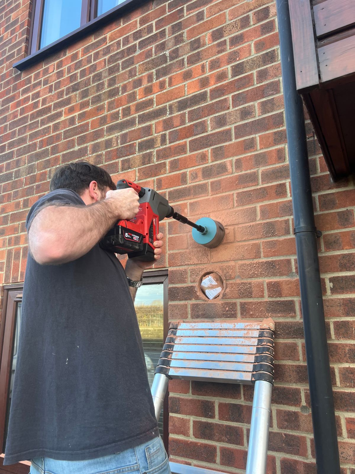 Core drilling a flue hole through the brickwork for a new boiler