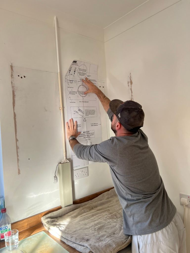Archie marking out a boiler position from the manufacturer template