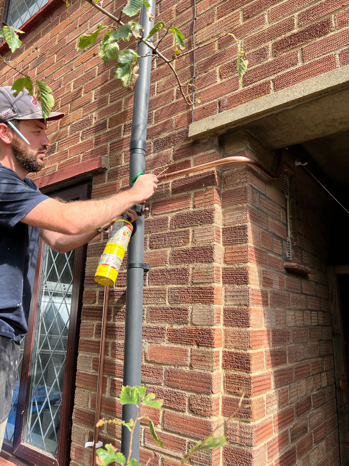 External copper pipework clipped to brickwork