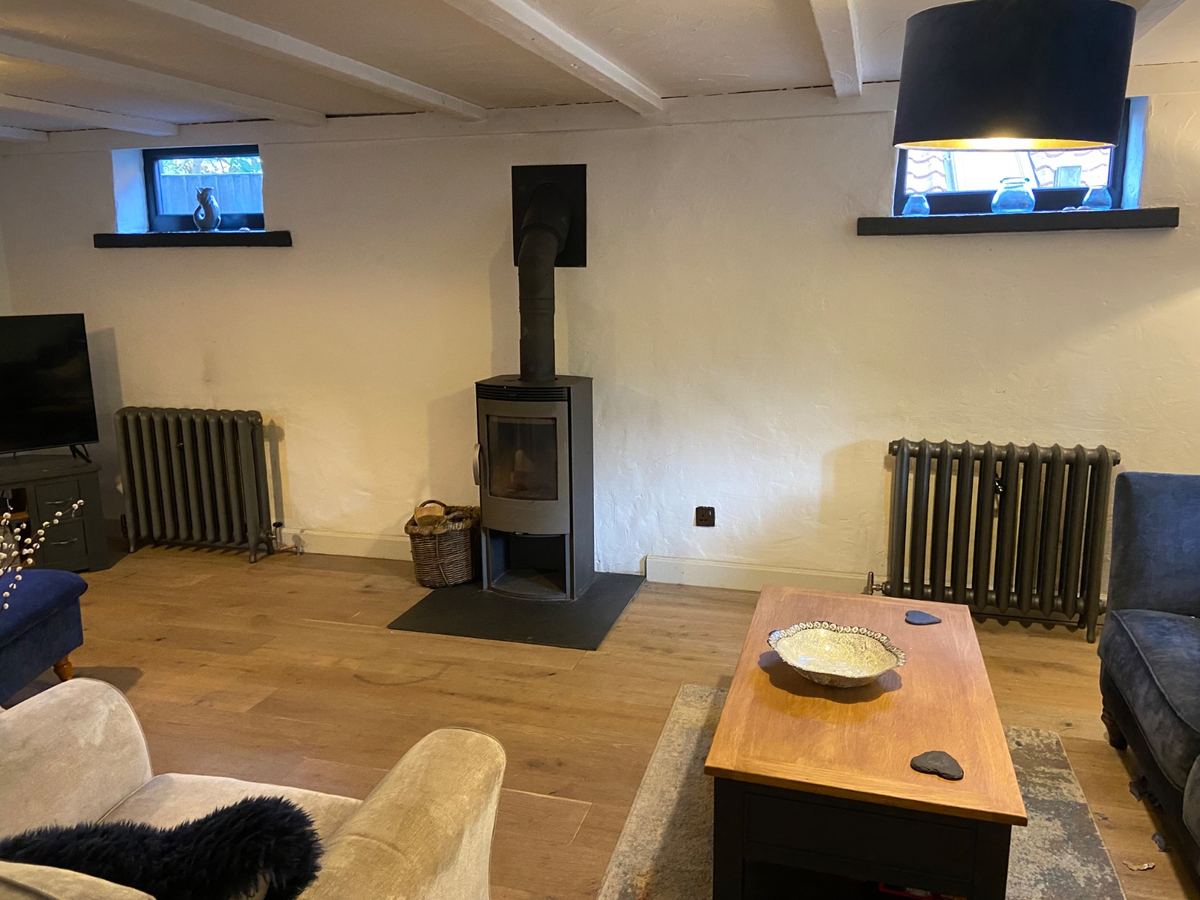 Lounge with a woodburner and newly fitted radiators